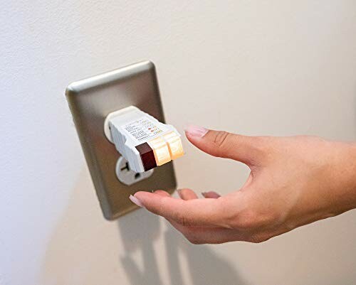 Hand using an electrical outlet tester plugged into a wall socket