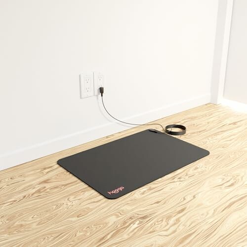 Grounding mat on wooden floor connected to wall outlet.